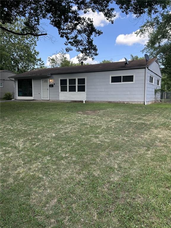 11001 Ewing Ave, Kansas City, MO 64134 - rear view of house featuring a lawn