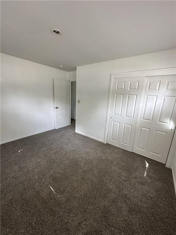 11001 Ewing Ave, Kansas City, MO 64134 - unfurnished bedroom featuring dark colored carpet and a closet