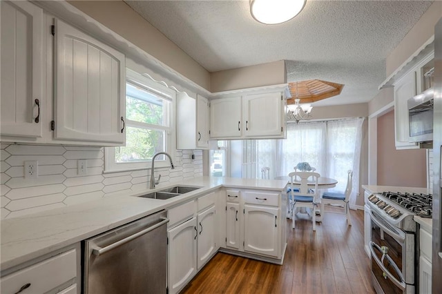1921 SW 4th St, Lees Summit, MO 64081 - kitchen featuring appliances with stainless steel finishes, white cabinets, a textured ceiling, a chandelier, and dark wood-style floors