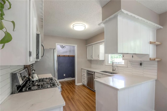 1921 SW 4th St, Lees Summit, MO 64081 - kitchen featuring stainless steel appliances, a textured ceiling, open shelves, tasteful backsplash, and light wood finished floors