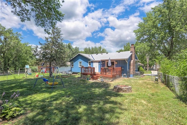 1921 SW 4th St, Lees Summit, MO 64081 - rear view of property with an outdoor fire pit, a fenced backyard, a wooden deck, a chimney, and a playground