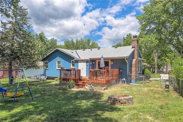 1921 SW 4th St, Lees Summit, MO 64081 - back of property with an outdoor fire pit, a fenced backyard, a chimney, a wooden deck, and board and batten siding