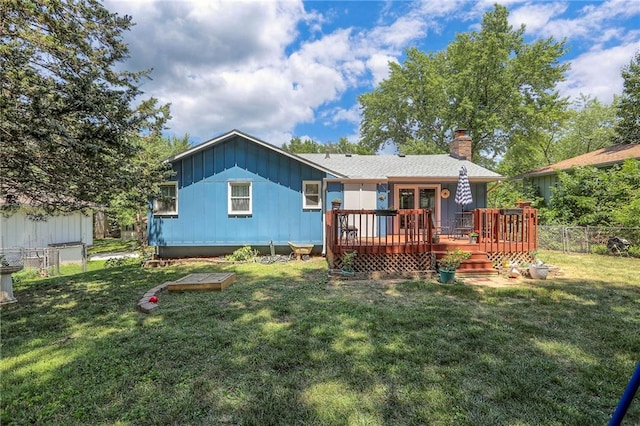 1921 SW 4th St, Lees Summit, MO 64081 - back of property with a deck, a fenced backyard, a chimney, and board and batten siding