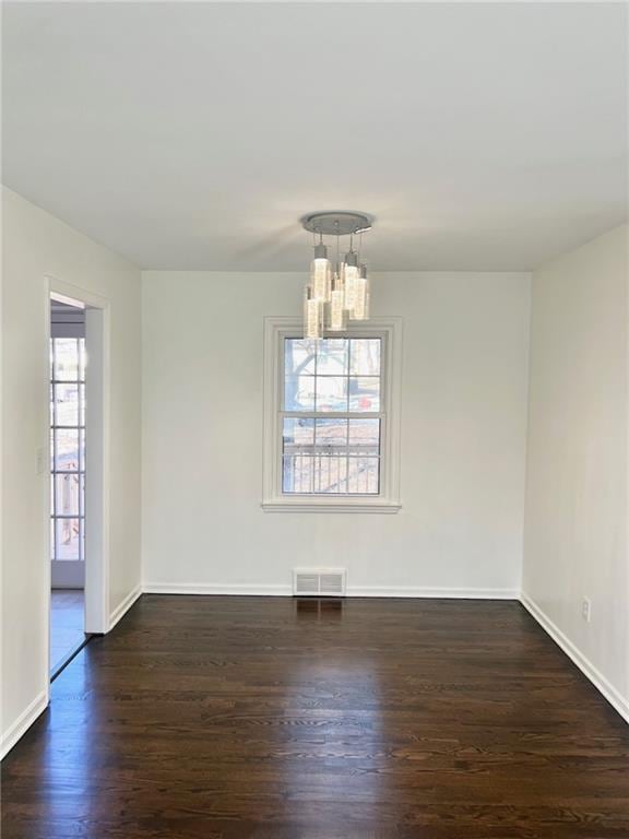 10806 W 96th St, Overland Park, KS 66214 - unfurnished room featuring dark wood-type flooring and a chandelier