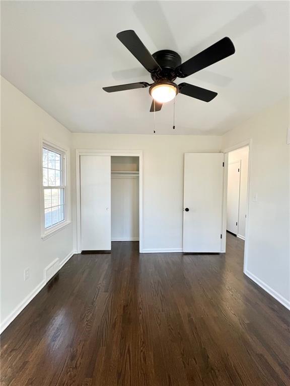 10806 W 96th St, Overland Park, KS 66214 - unfurnished bedroom with dark wood-style floors, a closet, and a ceiling fan
