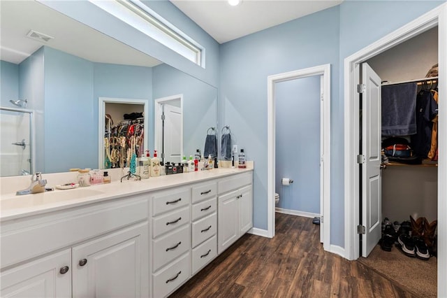 21904 Crystal Ave, Peculiar, MO 64078 - full bath featuring a walk in closet, double vanity, a shower stall, and wood finished floors