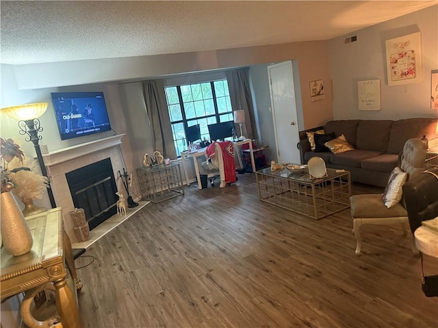 8135 Holmes Rd Unit 202, Kansas City, MO 64131 - living area with wood finished floors, a tile fireplace, and a textured ceiling
