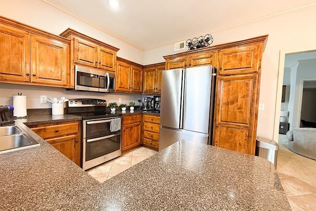 12748 Walker Ave, Kansas City, KS 66109 - kitchen with appliances with stainless steel finishes, brown cabinetry, dark countertops, and ornamental molding