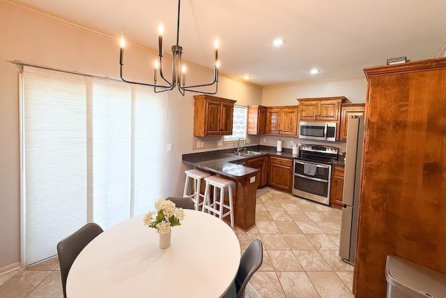 12748 Walker Ave, Kansas City, KS 66109 - kitchen featuring stainless steel appliances, a peninsula, ornamental molding, a chandelier, and brown cabinetry