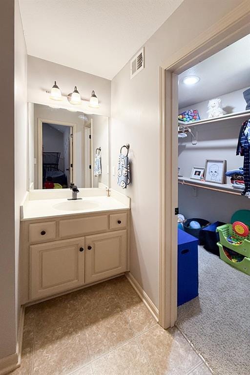 12748 Walker Ave, Kansas City, KS 66109 - bathroom featuring vanity, a spacious closet, and tile patterned flooring