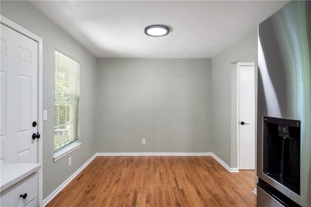 1304 E 41st St, Kansas City, MO 64110 - unfurnished dining area featuring light wood-type flooring and baseboards