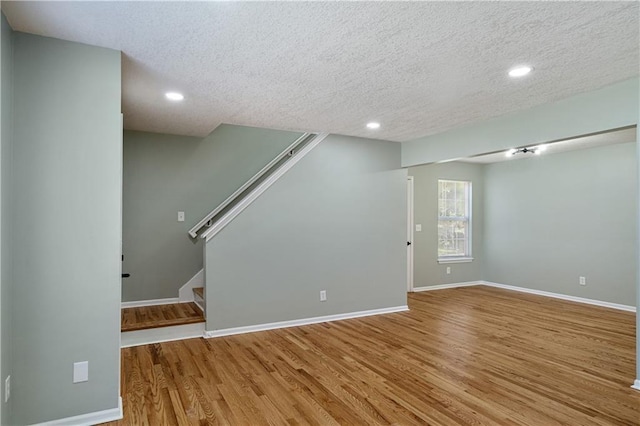 1304 E 41st St, Kansas City, MO 64110 - unfurnished living room with a textured ceiling, wood finished floors, stairway, and recessed lighting