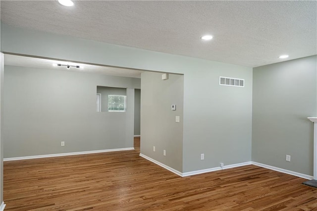 1304 E 41st St, Kansas City, MO 64110 - unfurnished room featuring wood finished floors, a textured ceiling, and recessed lighting