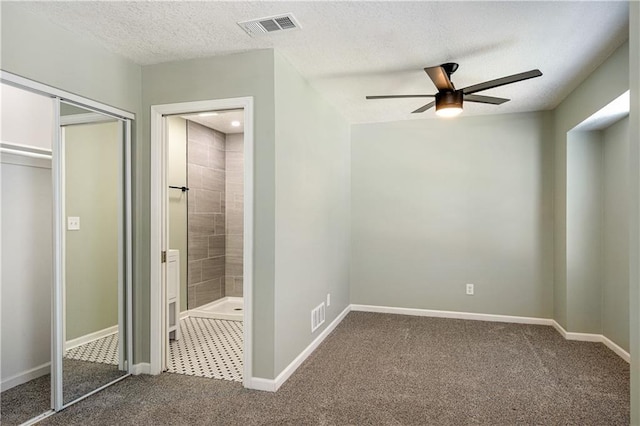 1304 E 41st St, Kansas City, MO 64110 - unfurnished bedroom with carpet, connected bathroom, a closet, a textured ceiling, and ceiling fan