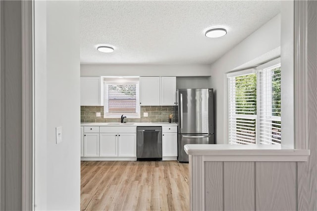 16620 E 36th St, Independence, MO 64055 - kitchen featuring stainless steel appliances, a textured ceiling, light countertops, white cabinetry, and plenty of natural light