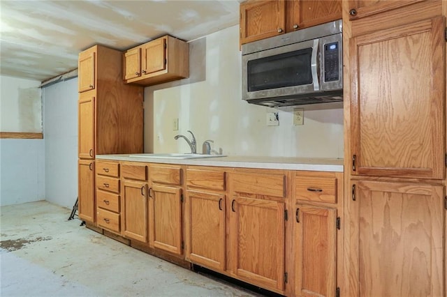 503 SE Brownfield Dr, Lees Summit, MO 64063 - kitchen featuring stainless steel microwave, unfinished concrete flooring, light countertops, and brown cabinets