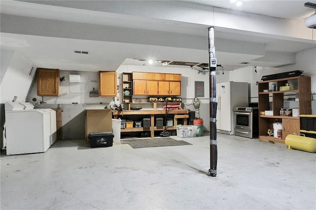 503 SE Brownfield Dr, Lees Summit, MO 64063 - garage featuring washing machine and clothes dryer and a workshop area
