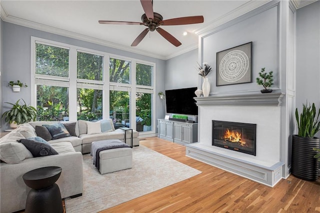 4140 W 131st Ter, Leawood, KS 66209 - living room featuring crown molding, wood finished floors, a large fireplace, and a ceiling fan