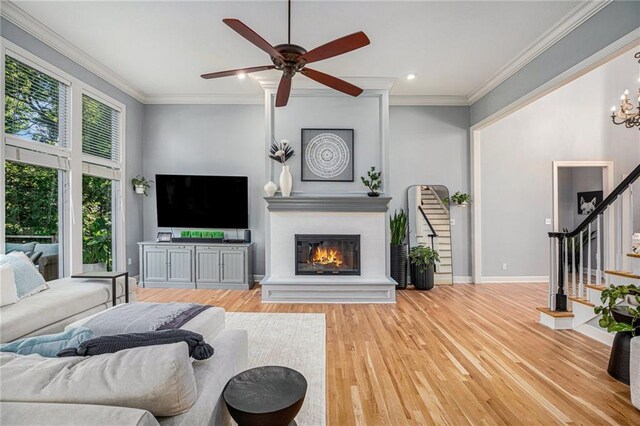 4140 W 131st Ter, Leawood, KS 66209 - living area with stairs, a large fireplace, wood finished floors, ornamental molding, and a ceiling fan