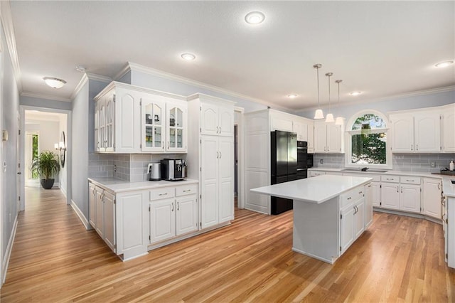4140 W 131st Ter, Leawood, KS 66209 - kitchen with a center island, light countertops, light wood-style flooring, ornamental molding, and recessed lighting