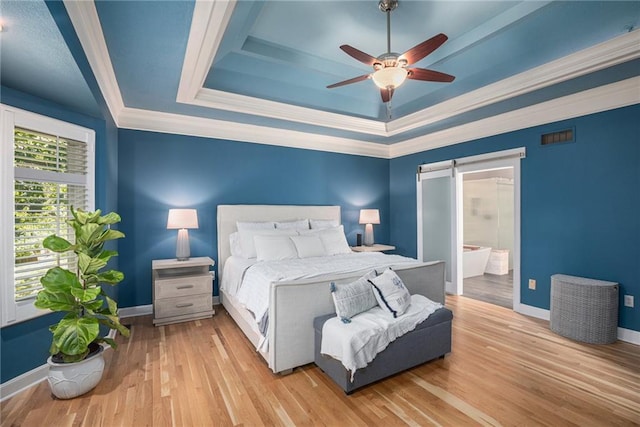 4140 W 131st Ter, Leawood, KS 66209 - bedroom featuring a tray ceiling, a barn door, wood finished floors, ornamental molding, and a ceiling fan