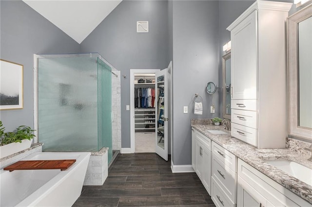 4140 W 131st Ter, Leawood, KS 66209 - bathroom featuring a stall shower, double vanity, a freestanding bath, a walk in closet, and wood finished floors