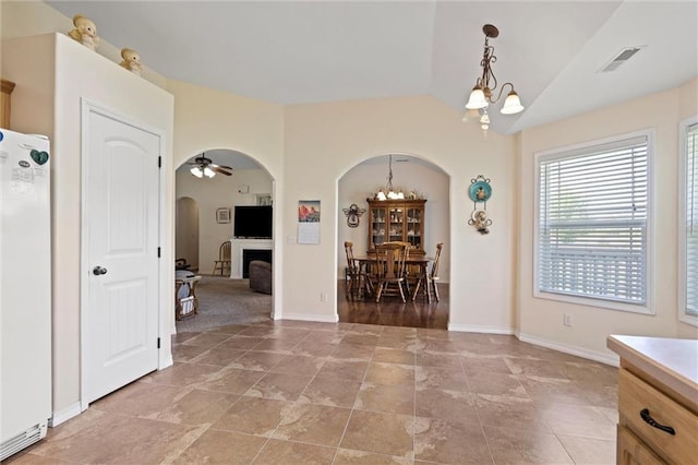 21506 Murlo Cir, Peculiar, MO 64078 - dining area featuring a chandelier, arched walkways, ceiling fan, and a fireplace