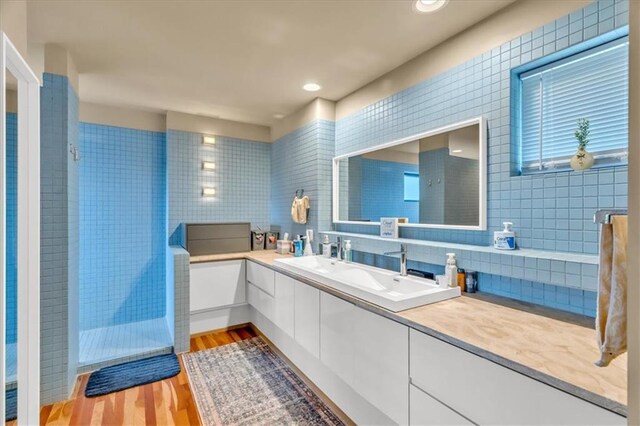 2400 Forest Ave, Kansas City, MO 64108 - bathroom with double vanity, wood finished floors, and backsplash