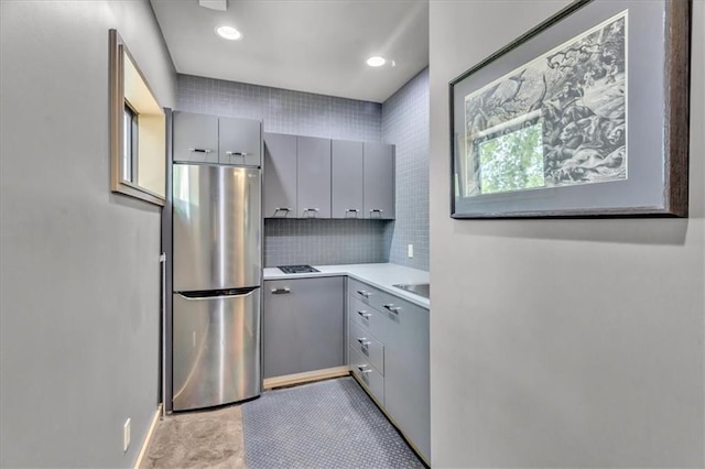 2400 Forest Ave, Kansas City, MO 64108 - kitchen featuring freestanding refrigerator, gray cabinets, light countertops, backsplash, and recessed lighting