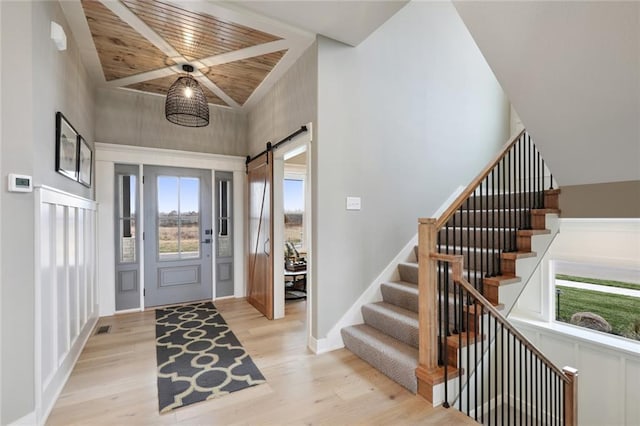 18608 Mohawk Ln, Overland Park, KS 66085 - foyer entrance featuring a barn door, light wood-style floors, stairs, and wooden ceiling
