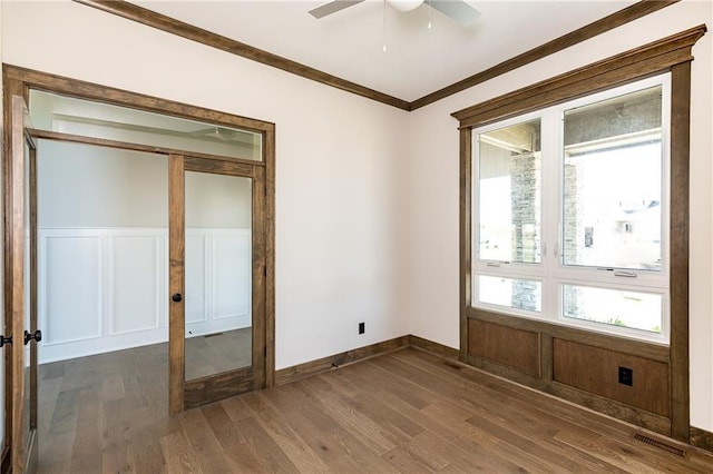 3361 W 187th St, Overland Park, KS 66085 - unfurnished room with ornamental molding, dark wood-style flooring, a ceiling fan, wainscoting, and a decorative wall