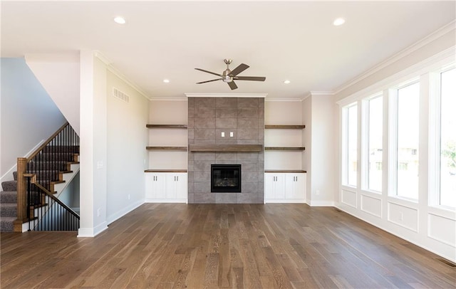 3361 W 187th St, Overland Park, KS 66085 - unfurnished living room with a ceiling fan, wood finished floors, crown molding, stairs, and a tiled fireplace