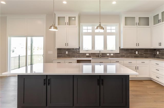 3361 W 187th St, Overland Park, KS 66085 - kitchen with a kitchen island, recessed lighting, white cabinets, decorative backsplash, and light countertops