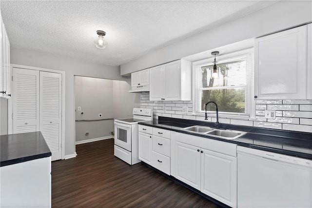 1313 S Clark Ave, Independence, MO 64057 - kitchen featuring white appliances, dark countertops, under cabinet range hood, dark wood-style flooring, and white cabinets