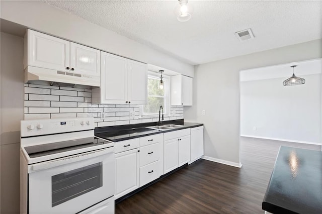 1313 S Clark Ave, Independence, MO 64057 - kitchen with white appliances, under cabinet range hood, dark countertops, backsplash, and a textured ceiling