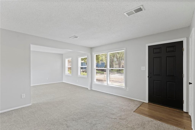 1313 S Clark Ave, Independence, MO 64057 - carpeted foyer featuring a textured ceiling and baseboards