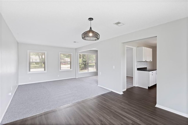 1313 S Clark Ave, Independence, MO 64057 - unfurnished living room featuring dark wood-style flooring and plenty of natural light