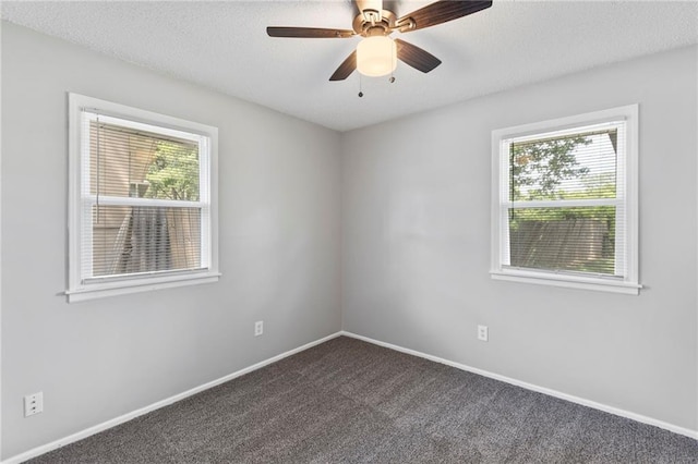 1313 S Clark Ave, Independence, MO 64057 - spare room featuring healthy amount of natural light, dark colored carpet, a ceiling fan, and a textured ceiling