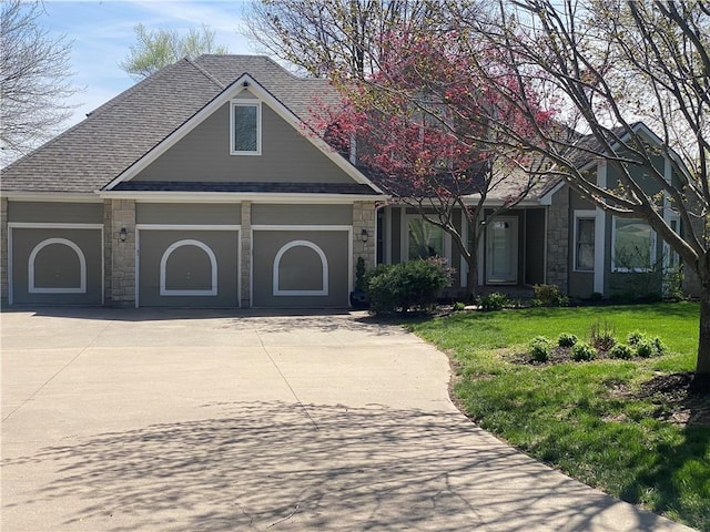 24445 E Truman Rd, Independence, MO 64056 - view of front of house with stone siding, concrete driveway, a front yard, and an attached garage