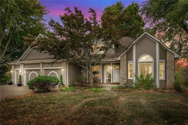 24445 E Truman Rd, Independence, MO 64056 - view of front of property featuring stone siding, covered porch, driveway, and a garage