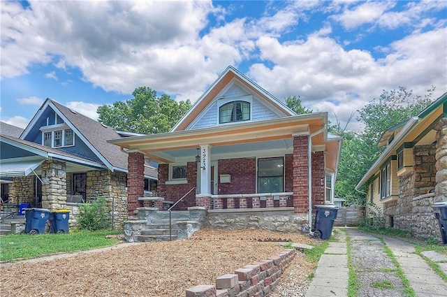 3923 Campbell St, Kansas City, MO 64110 - bungalow featuring a porch, brick siding, and driveway