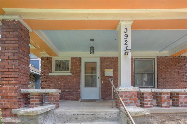 3923 Campbell St, Kansas City, MO 64110 - doorway to property with covered porch and brick siding