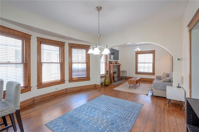 3923 Campbell St, Kansas City, MO 64110 - living area with wood finished floors, healthy amount of natural light, arched walkways, and a chandelier