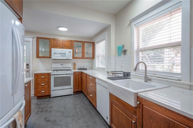 3923 Campbell St, Kansas City, MO 64110 - kitchen with white appliances, brown cabinets, decorative backsplash, and light countertops