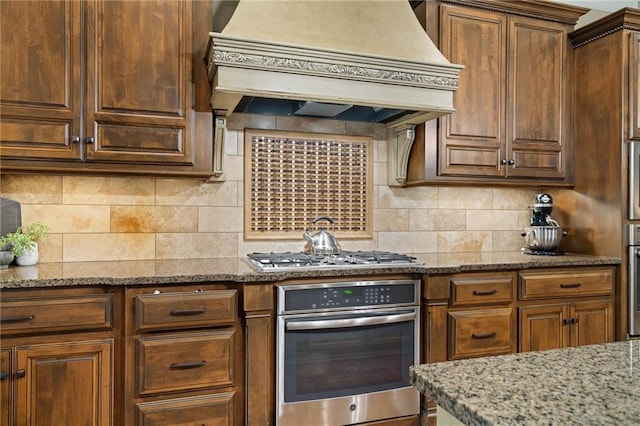 3116 W 137th St, Leawood, KS 66224 - kitchen with appliances with stainless steel finishes, custom exhaust hood, light stone countertops, and tasteful backsplash