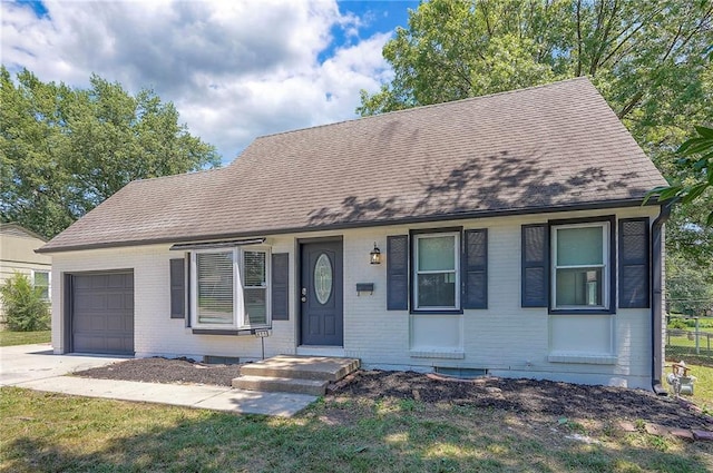 611 Pawnee Ln, Belton, MO 64012 - view of front of home with brick siding, an attached garage, a shingled roof, and concrete driveway