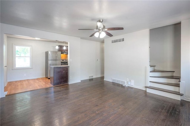 611 Pawnee Ln, Belton, MO 64012 - unfurnished living room with ceiling fan, wood finished floors, and stairs