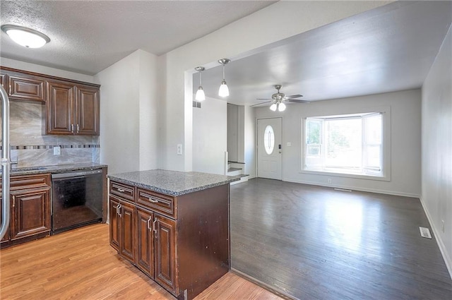 611 Pawnee Ln, Belton, MO 64012 - kitchen with dishwasher, light wood-style flooring, a ceiling fan, and dark stone countertops