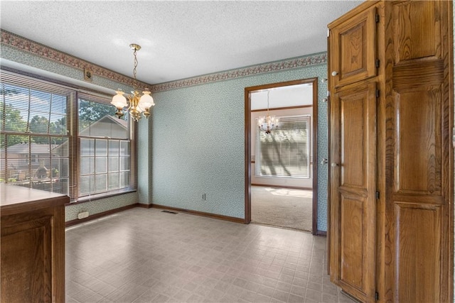 2117 Parker Ct, Blue Springs, MO 64015 - unfurnished dining area featuring a chandelier, a textured ceiling, healthy amount of natural light, wallpapered walls, and light floors