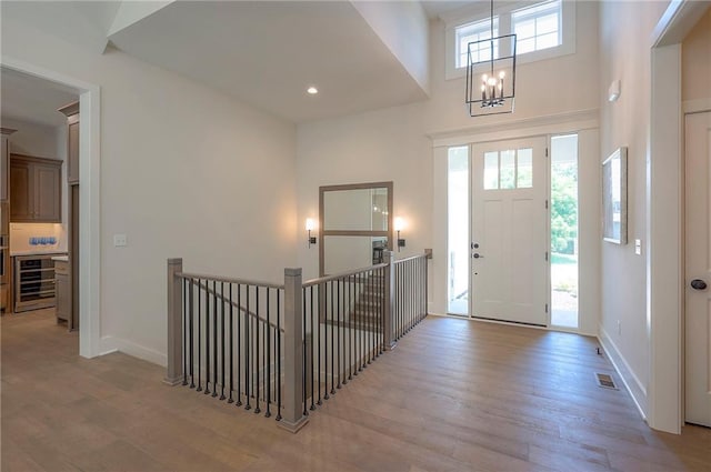 6753 Longview St, Shawnee, KS 66218 - foyer entrance featuring light wood-type flooring, a high ceiling, a chandelier, and recessed lighting